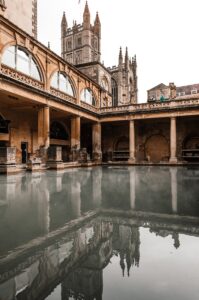 Old temple facade reflecting in Roman Baths in England