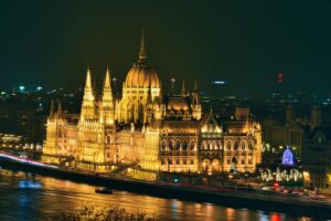 Stunning night view of the illuminated Hungarian Parliament Building reflecting on the Danube River in Budapest.