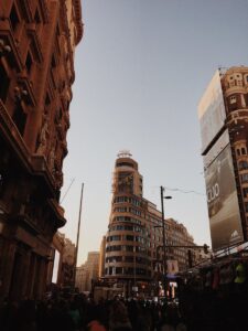 A bustling scene of Madrid's Calle Gran Vía with the prominent Edificio Capitol at dusk, capturing the city's vibrant energy.