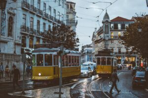 Scenic view of trams navigating the charming streets of Lisbon at dusk, capturing urban life and transportation.