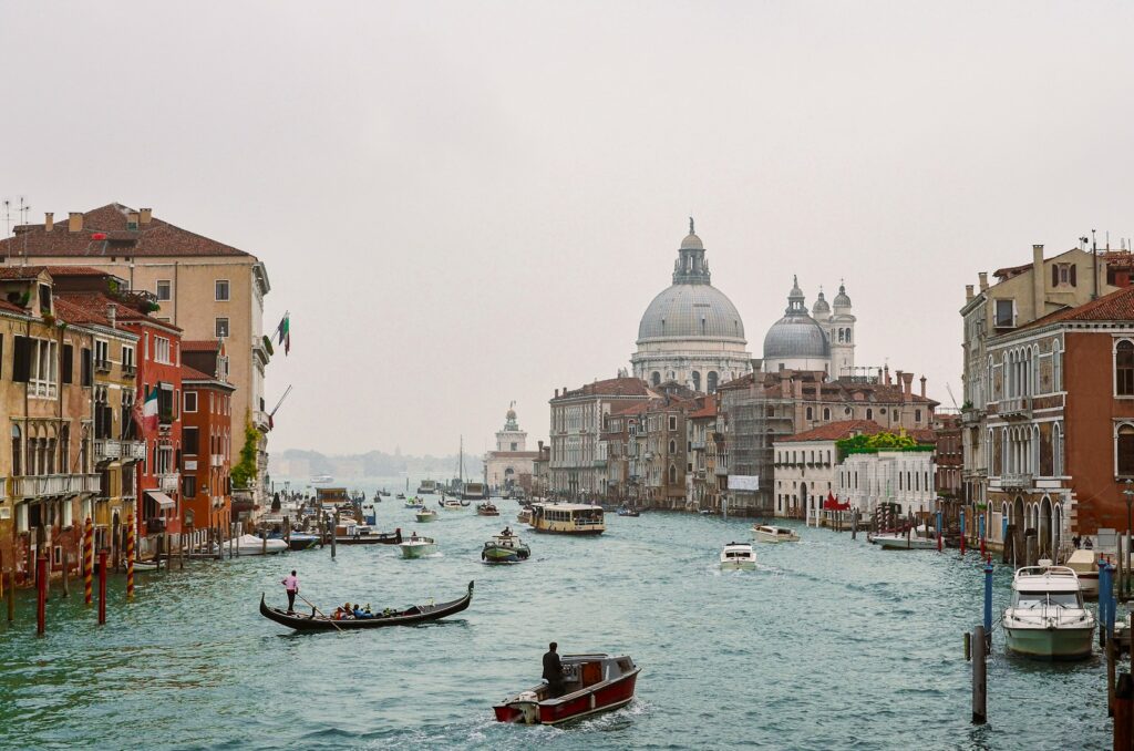 a body of water with boats in it and buildings around it with Grand Canal in the background