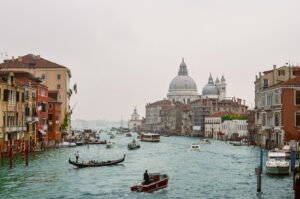 a body of water with boats in it and buildings around it with Grand Canal in the background