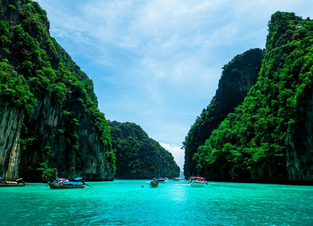 boats on sea near mountain during daytime