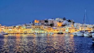 city buildings near body of water during night time