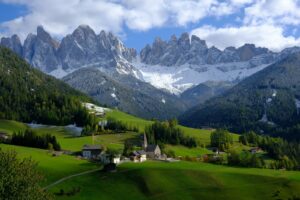 green grass field near snow covered mountain during daytime