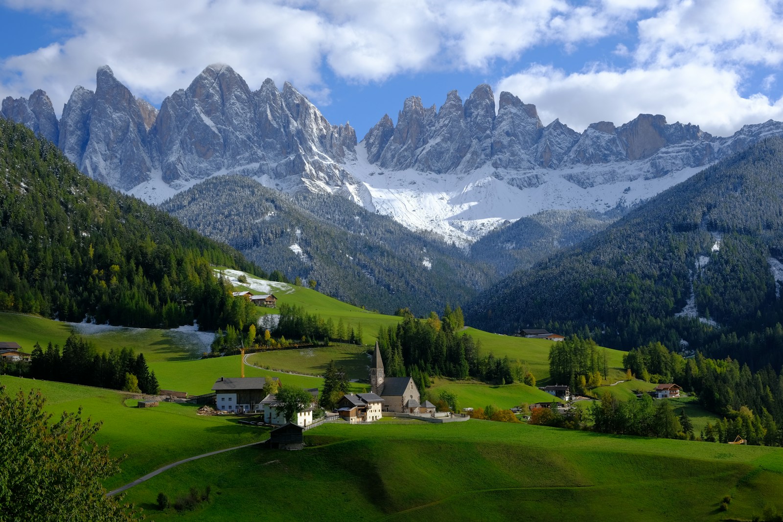 green grass field near snow covered mountain during daytime