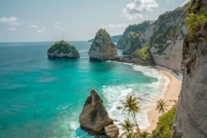 Turquoise water and sandy beach below limestone cliffs in Nusa Penida, Indonesia